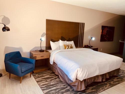a bedroom with a large bed and a blue chair at Zion Canyon Lodge in Springdale