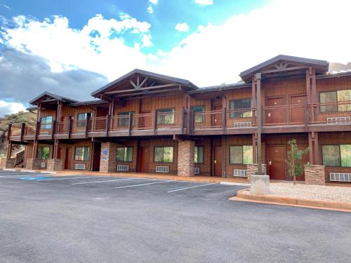 a large building with a parking lot in front of it at Zion Canyon Lodge in Springdale
