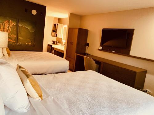 a hotel room with two beds and a flat screen tv at Zion Canyon Lodge in Springdale
