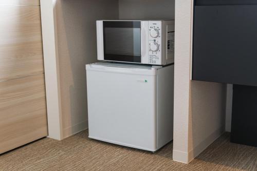 a microwave on top of a refridgerator with a refrigerator at GRAND BASE Mojiko in Kitakyushu