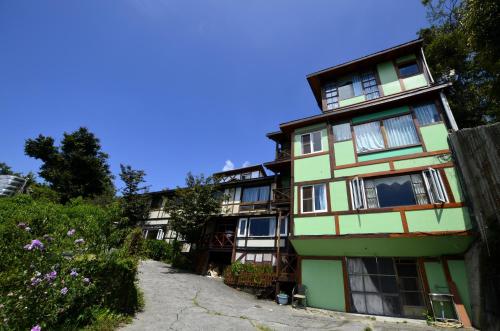 an apartment building in the mountains with a driveway at Shiyai Taoyuan in Renai