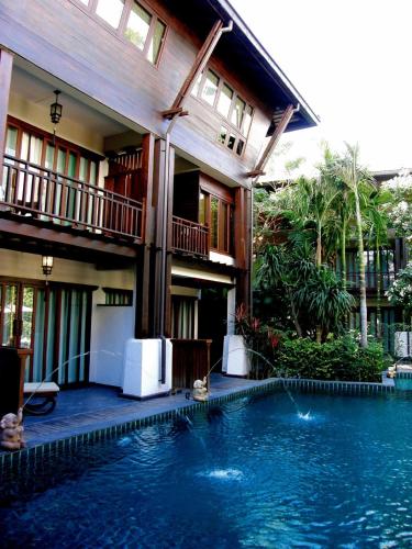 a house with a swimming pool in front of a house at Yantarasri Resort in Chiang Mai