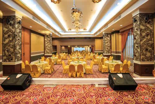 a banquet hall with tables and chairs and a chandelier at Kwan Ruen Park in Nakhon Ratchasima