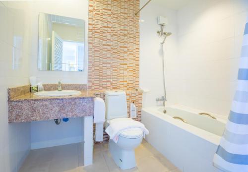 a bathroom with a toilet and a sink and a tub at Kwan Ruen Park in Nakhon Ratchasima
