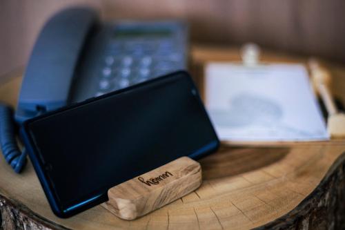 a wooden table with a cell phone and a book at HOMM Boutique Hotel in Chiang Mai