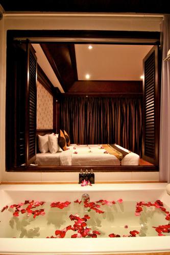 a bedroom with a bed and a large mirror at Rayaburi Hotel, Patong in Patong Beach
