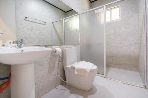 a bathroom with a toilet and a sink and a shower at Sur Beach Resort Boracay in Boracay