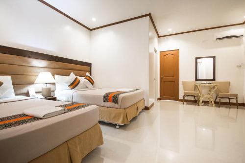 a hotel room with two beds and a desk at Sur Beach Resort Boracay in Boracay