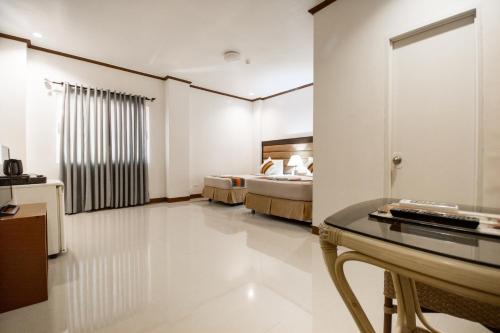 a hotel room with two beds and a table at Sur Beach Resort Boracay in Boracay