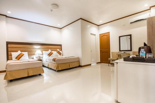 a hotel room with two beds and a counter at Sur Beach Resort Boracay in Boracay