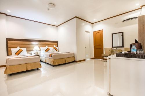 a hotel room with two beds in a room at Sur Beach Resort Boracay in Boracay