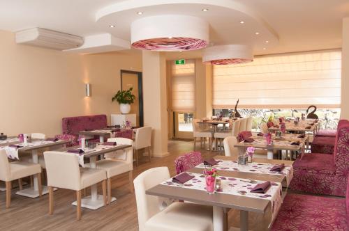 a restaurant with tables and chairs and pink furniture at Het Wapen van Elst in Elst