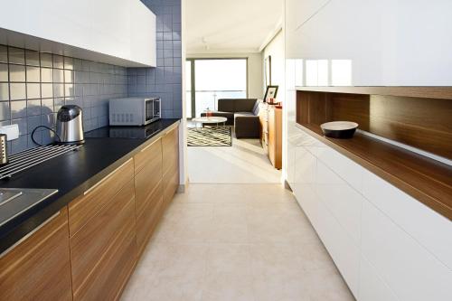 a kitchen with black countertops and a living room at Apartamenty Na Klifie in Ustronie Morskie