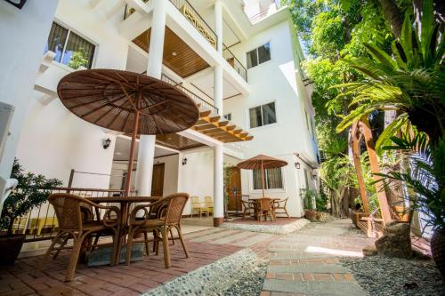a patio with a table and chairs and an umbrella at Sur Beach Resort Boracay in Boracay