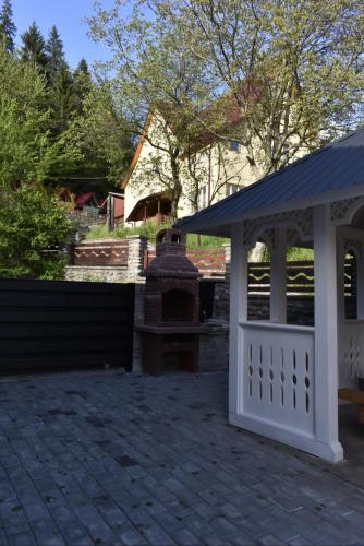 a white gazebo with a fireplace in a yard at Cazare Moldi Btt in Câmpulung Moldovenesc