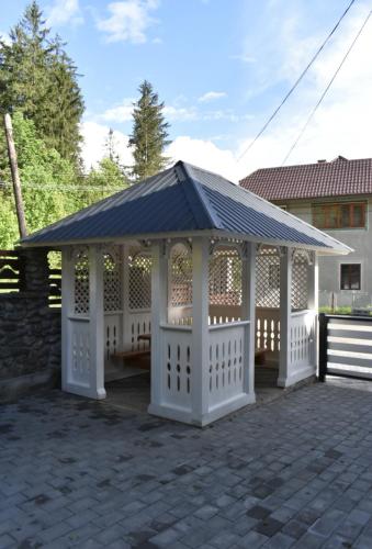 a gazebo with a black roof on a patio at Cazare Moldi Btt in Câmpulung Moldovenesc
