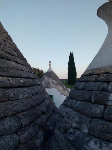 a view of a stone wall with a tree in the background at Trulli di Ivana in Ostuni
