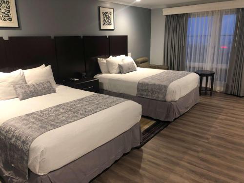 a hotel room with two beds and a table at Best Western Plus Dana Point Inn-by-the-Sea in Dana Point