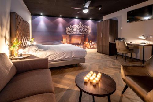 a bedroom with a bed and a couch and a table at Fletcher Hotel-Restaurant de Korenbeurs in Made