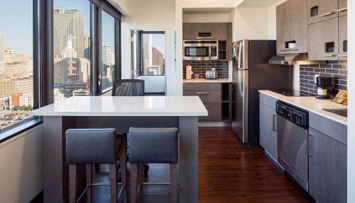 a kitchen with a counter with chairs and a large window at Hyatt House New Orleans Downtown in New Orleans