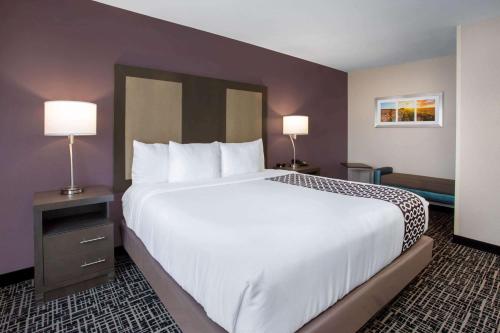 a large bed in a hotel room with two lamps at La Quinta by Wyndham Wichita Airport in Wichita