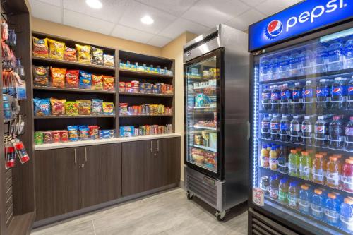 a store aisle with a soda cooler and aepsi refrigerator at La Quinta by Wyndham Wichita Airport in Wichita