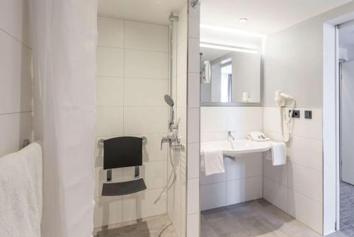 a bathroom with a shower and a sink at Ramada by Wyndham Flensburg City in Flensburg