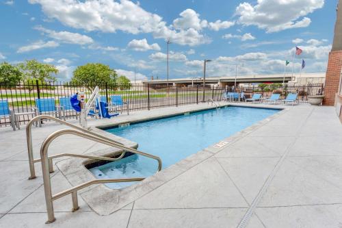 - une piscine avec des chaises et une clôture dans l'établissement La Quinta by Wyndham Wichita Airport, à Wichita