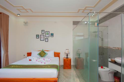 a bedroom with a bed and a glass shower at Riverside Sunset Homestay in Hoi An