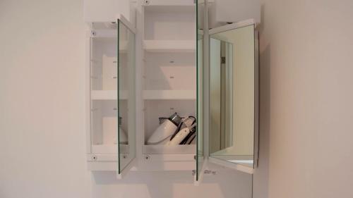 a glass cabinet with two mirrors on a wall at beautiful Mt.Fuji B in Fujikawaguchiko
