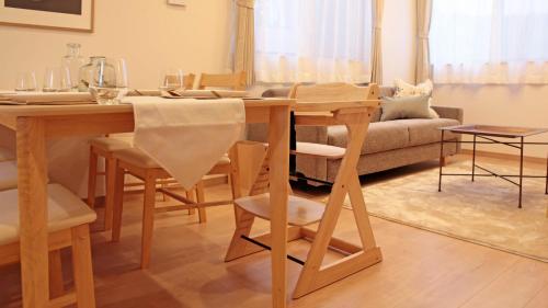 a dining room with a table and a couch at beautiful Mt.Fuji A in Fujikawaguchiko