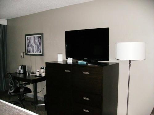 a bedroom with a dresser with a tv and a desk at Best Western Plus Bradford Inn in Bradford