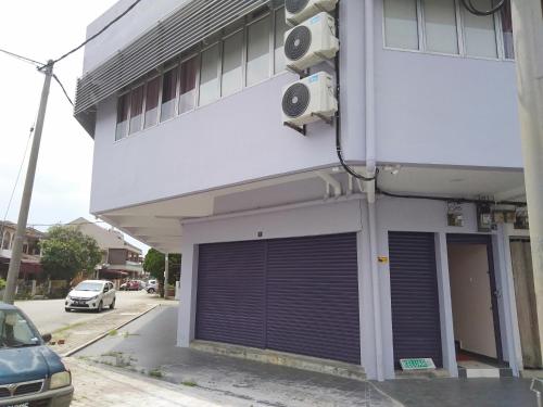 a building with a garage door on the side of it at Purple Dream Home in Teluk Panglima Garang