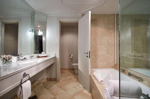
a bathroom with a tub, toilet, sink and shower at Hyatt Regency Belgrade in Belgrade
