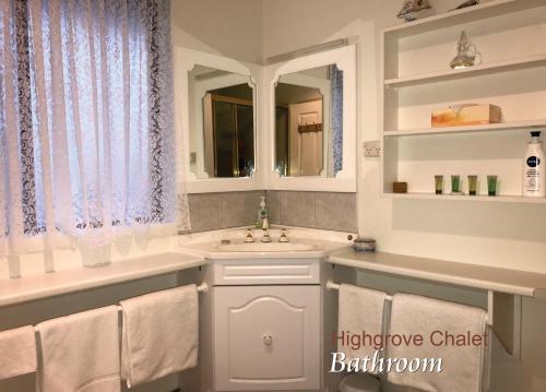 uma casa de banho com um lavatório e um espelho em Highgrove em Promised Land