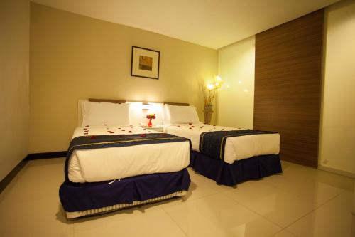 a hotel room with two beds in a room at Mangga Boutique Hotel in Seri Kembangan