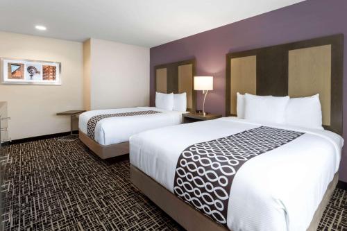 two beds in a hotel room with two beds at La Quinta by Wyndham Wichita Airport in Wichita