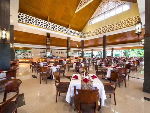 a dining room with tables and chairs in a restaurant at Puri Asri Hotel & Resort in Magelang