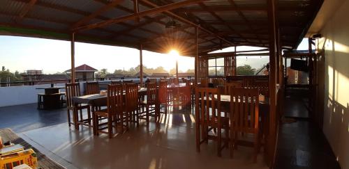 ein Restaurant mit Holzstühlen und Tischen auf dem Dach in der Unterkunft Song of Travel Hostel in Nyaung Shwe