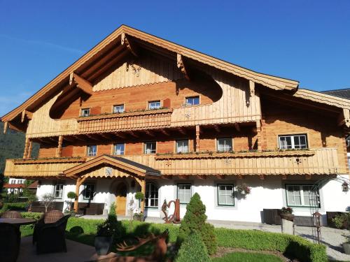 a large wooden house with a gambrel roof at Haslgut in Fuschl am See