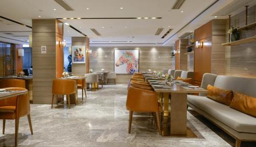 a restaurant with tables and chairs in a room at Paco Hotel Datang Metro Guangzhou-Free shuttle bus for canton fair in Guangzhou
