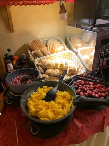 a table with a pan of scrambled eggs and other foods at Meuble Villa Neve in Cortina dʼAmpezzo