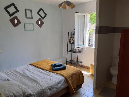 カルパントラにあるLa Maison d'Ogoouéのベッドルーム1室(青いタオル付きのベッド1台付)