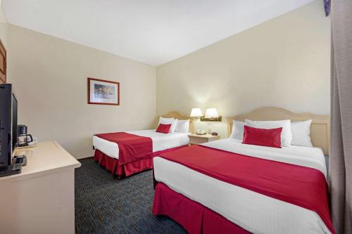 a hotel room with two beds and a flat screen tv at Quality Inn Aguascalientes in Aguascalientes