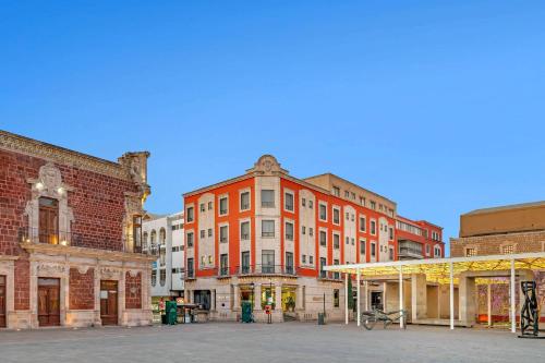 a group of brick buildings in a city at Quality Inn Aguascalientes in Aguascalientes