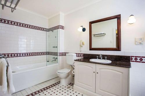 a bathroom with a sink and a tub and a toilet at Quality Hotel Bentinck in Portland