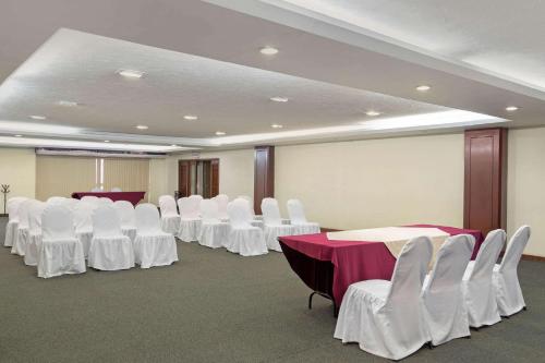 a conference room with white tables and white chairs at Quality Inn Aguascalientes in Aguascalientes