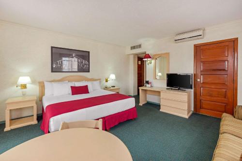 a hotel room with a bed and a television at Quality Inn Aguascalientes in Aguascalientes