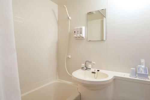 a bathroom with a sink, toilet and mirror at Comfort Inn Kashima in Fukashiba