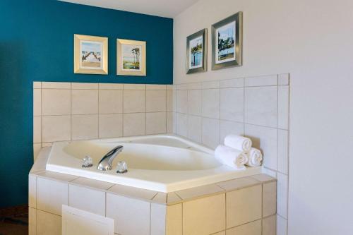 a bathroom with a bath tub with a sink at Quality Inn Gulfport I-10 in Gulfport